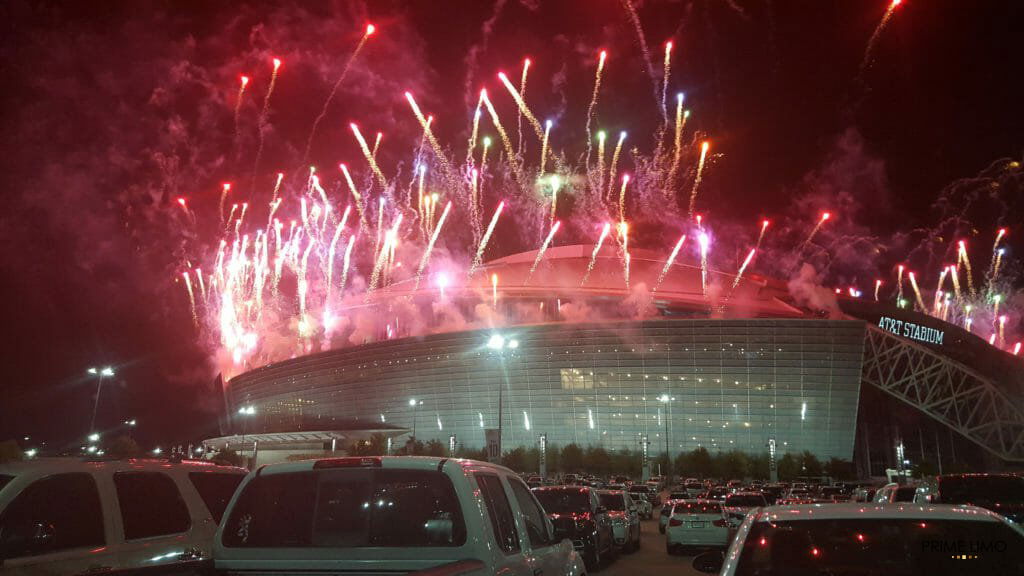 Picture of the AT&T Stadium in the evening with red fireworks shooting out of it.