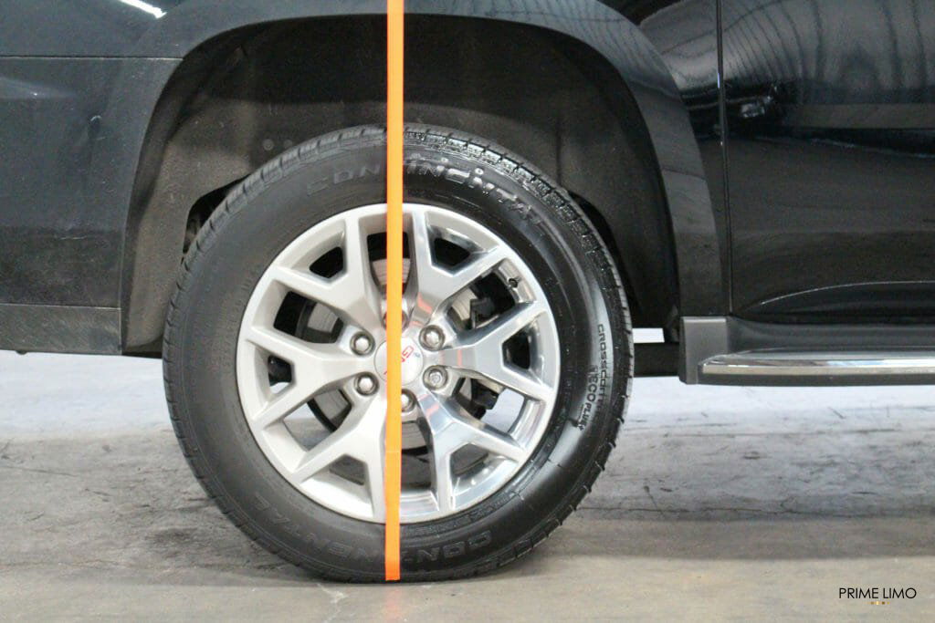 Orange tape separating a tire with a very dirty side and a completely clean side on a black Yukon XL