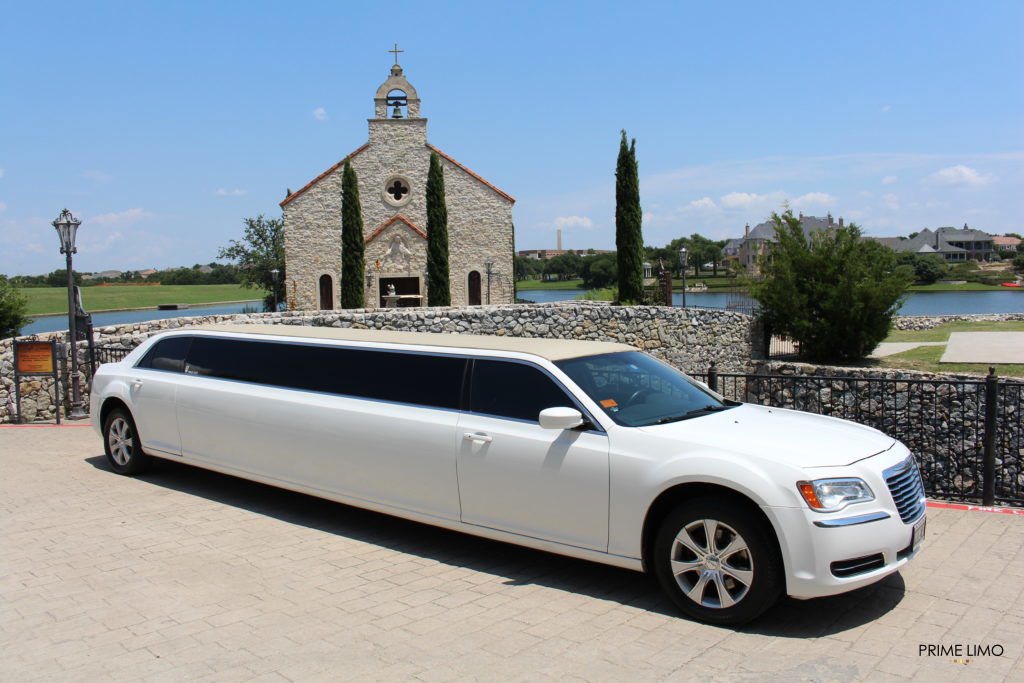 White Chrysler 300 limo in front of a church on a bright sunny day